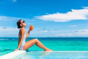 Γυναίκα κάνει ηλιοθεραπία σε πισίνα και πίνει χυμό καρότο