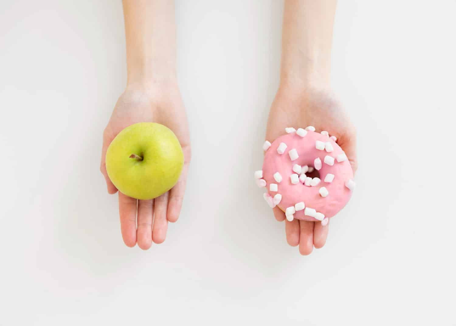 Φωτογραφία με μια γυναίκα να κρατάει μήλο και ντόνατς σε άρθρο για το μεταβολικό σύνδρομο