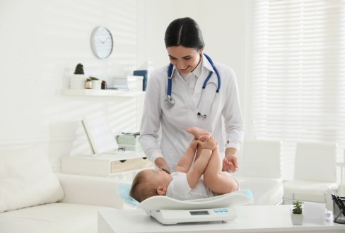 Παιδιάτρος εξετάζει μωρό στην πρώτη επίσκεψη στον παιδίατρο